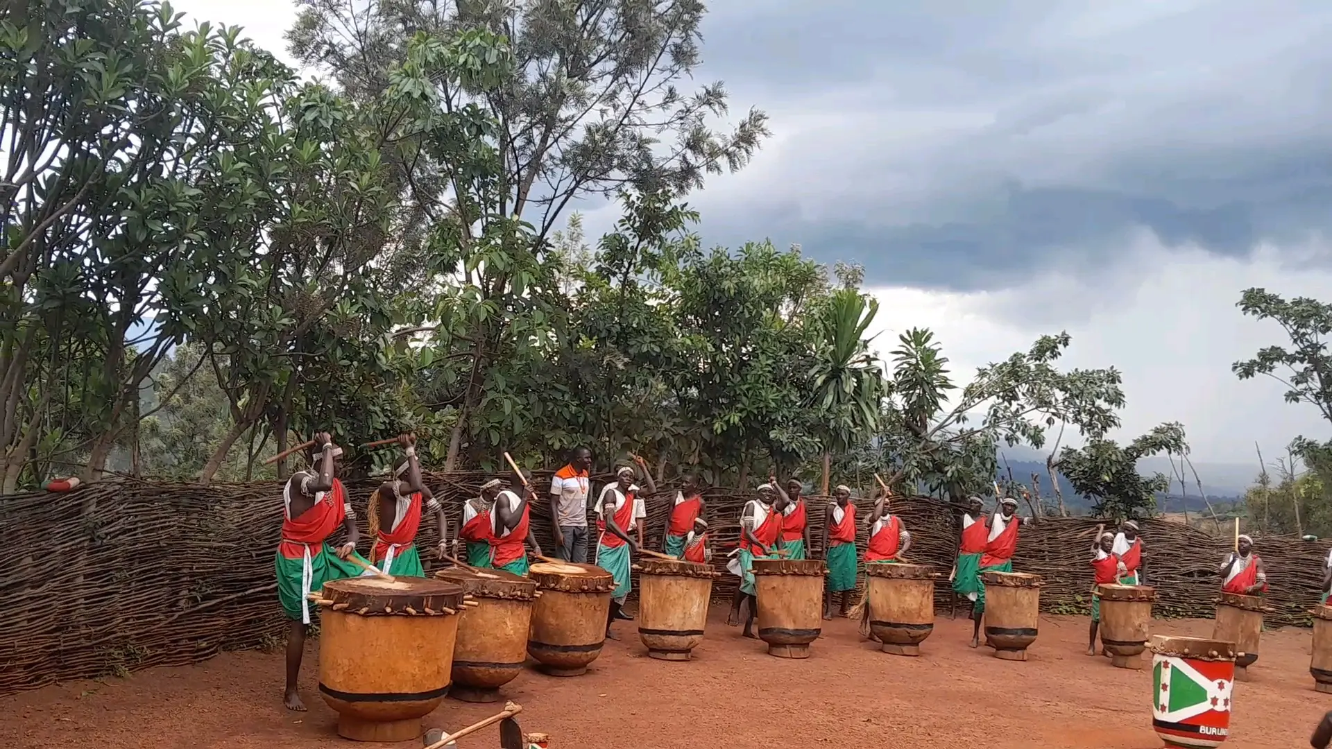 A line of Burundian royal drummers performing with traditional drums in Gitega
